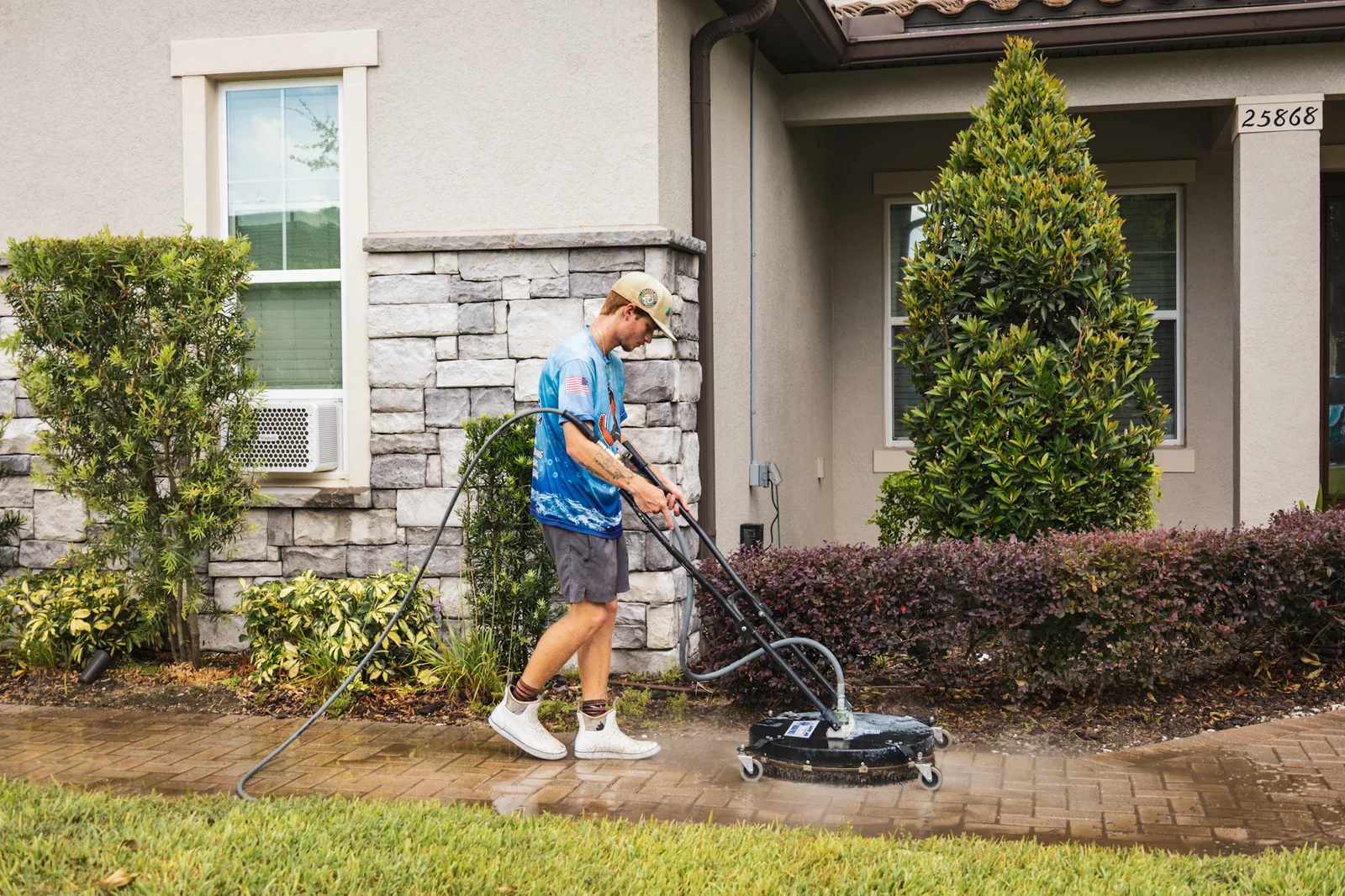 An All Elite technician surface cleaning a Florida driveway